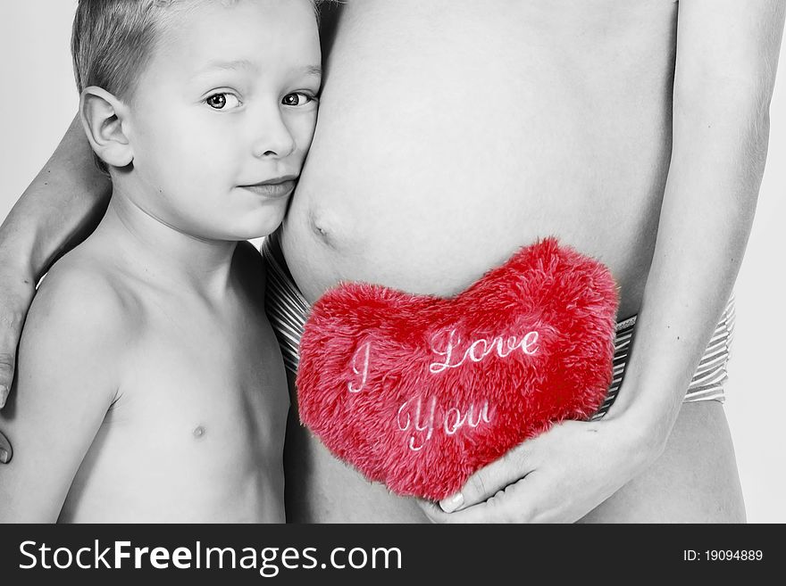 Pregnant mum with her son and toy heart. Pregnant mum with her son and toy heart