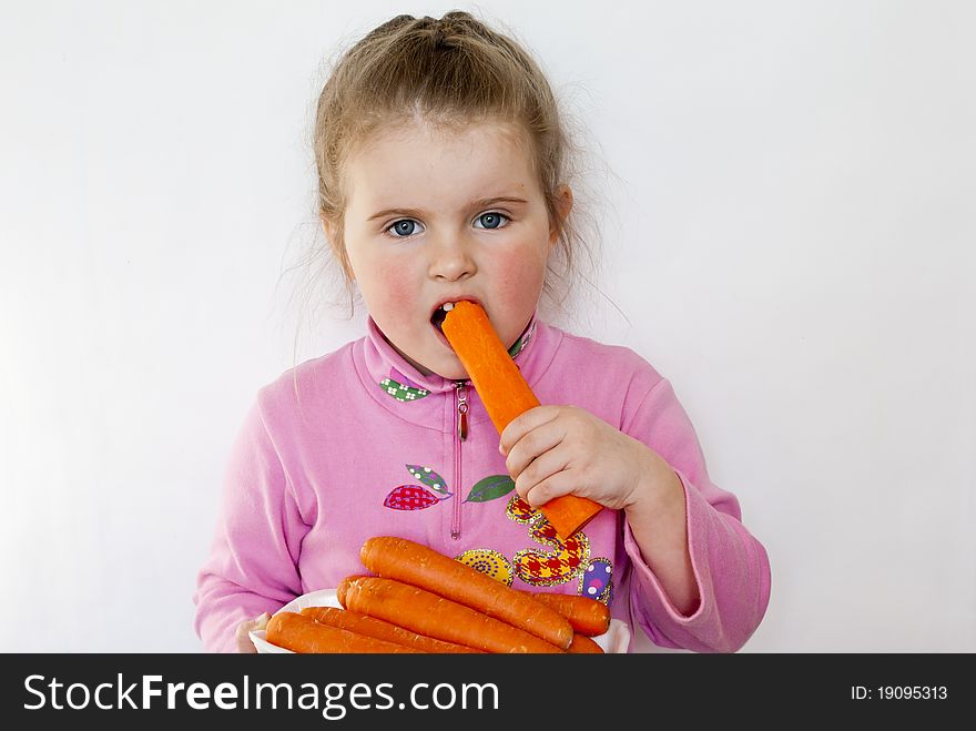 The girl eats carrots - a source of vitamins and microcells