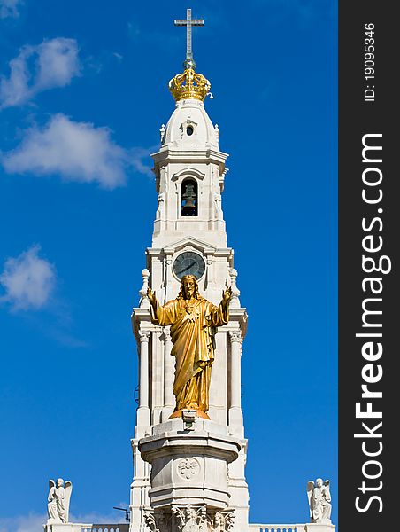 Statue of the Sacred Heart with the bell tower of Our Lady of the Rosary basilica behind. Statue of the Sacred Heart with the bell tower of Our Lady of the Rosary basilica behind