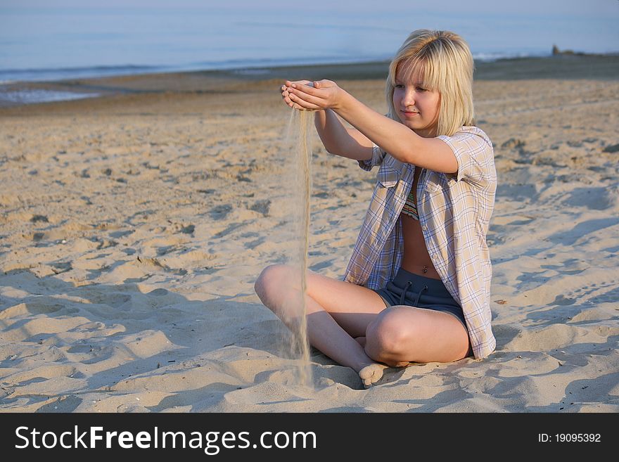 Girl plays sand on beach. Girl plays sand on beach.