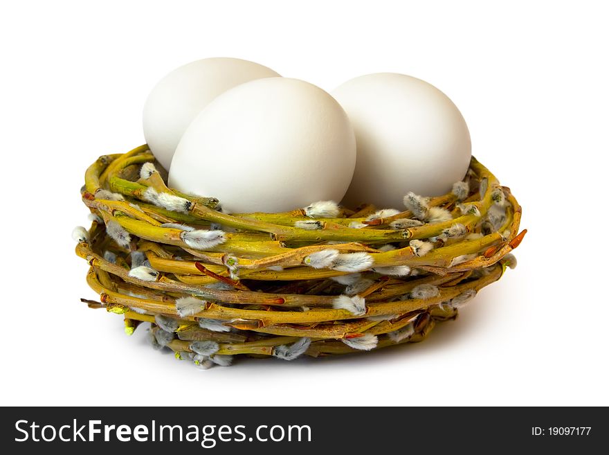 Willow nest with three white eggs isolated on a white background