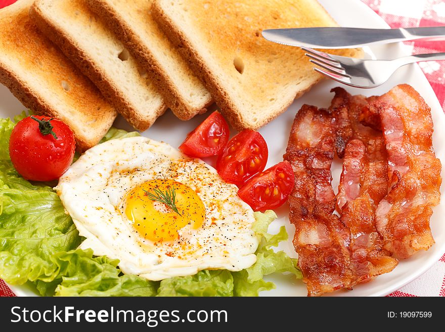 Breakfast of egg, bacon, toast and vegetables. Breakfast of egg, bacon, toast and vegetables