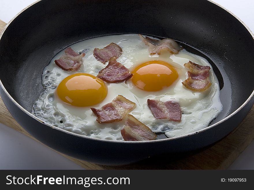 Fried eggs with bacon on the pan