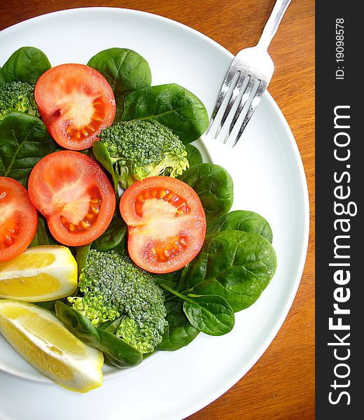 Salad with broccoli,spinach and tomatoes on white dish