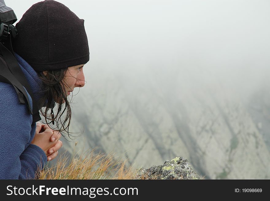 Girl sitting on the edge of a mountain. Carpathians, Romania
