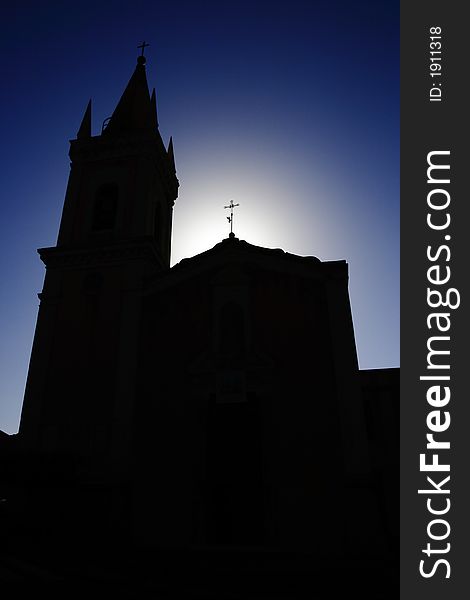 Photo of a church illuminated from behind. Photo of a church illuminated from behind.