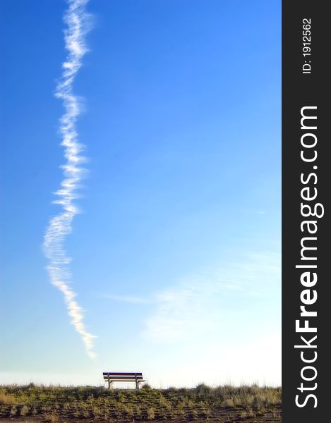 A dreamy lookout, bench against blue sky