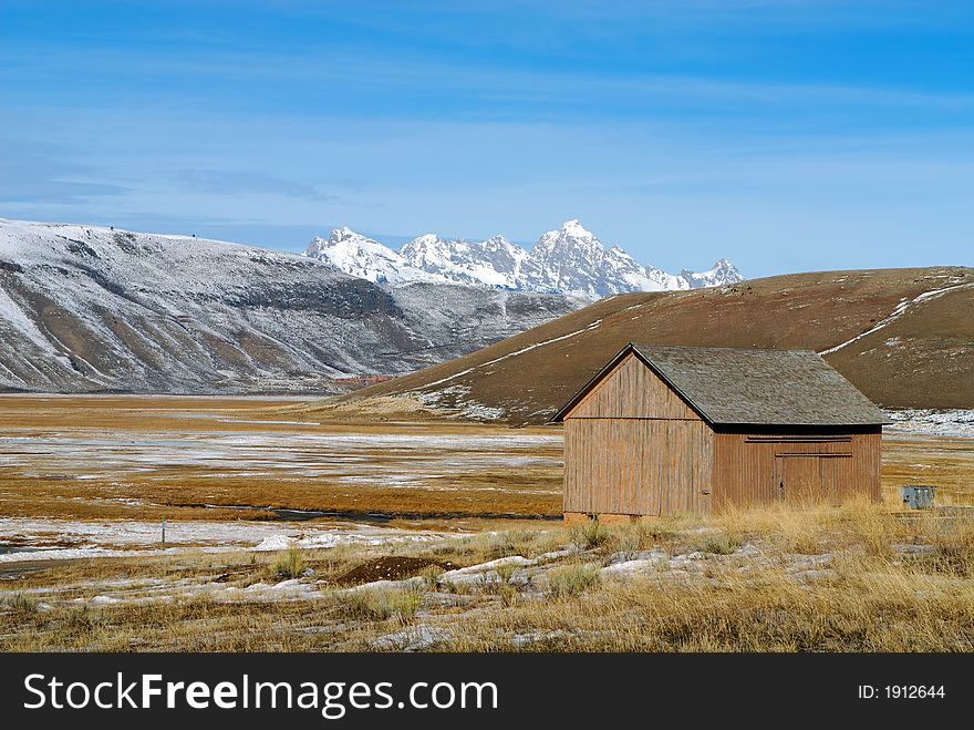Barn With Snow Covered Mountains in the Background. Barn With Snow Covered Mountains in the Background