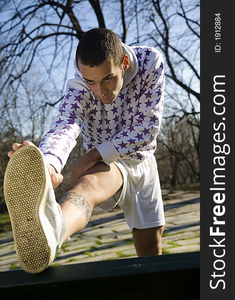 Healthy lifestyle: man doing stretching in a park. Healthy lifestyle: man doing stretching in a park