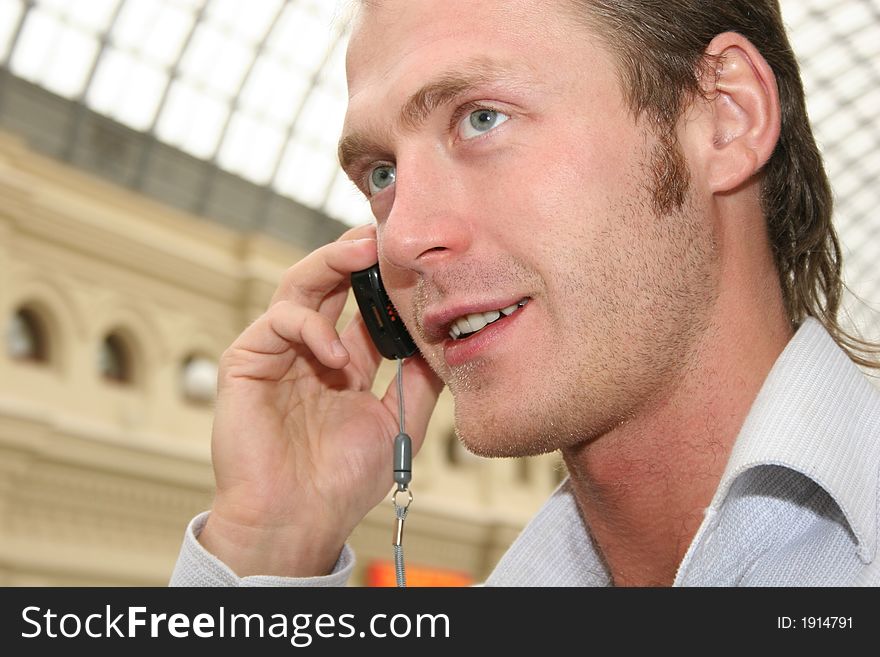 Man with phone in a white shirt portrait