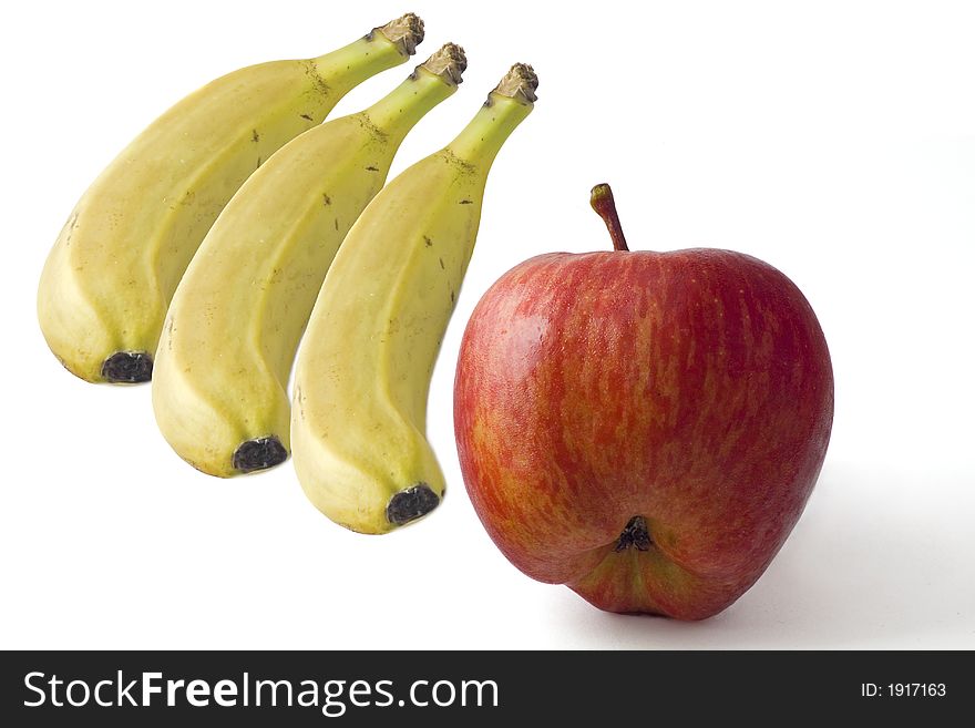 Three bananas and a red apple displayed on a white background indicating freshness. Three bananas and a red apple displayed on a white background indicating freshness