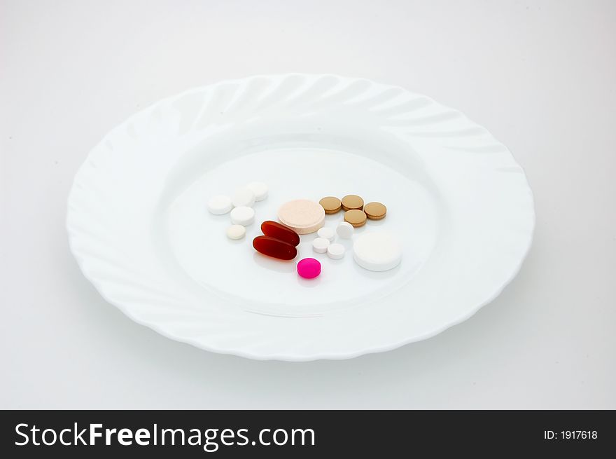 Isolated various pills on a plate. Isolated various pills on a plate.