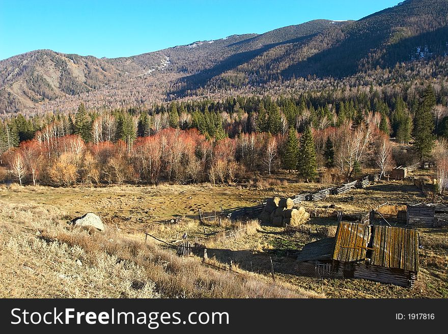 Old house, blue sky and mountains. Altay. Russia.