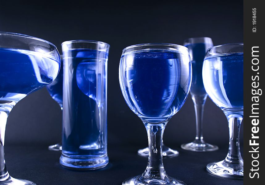 Glasses with a blue drink on a black background