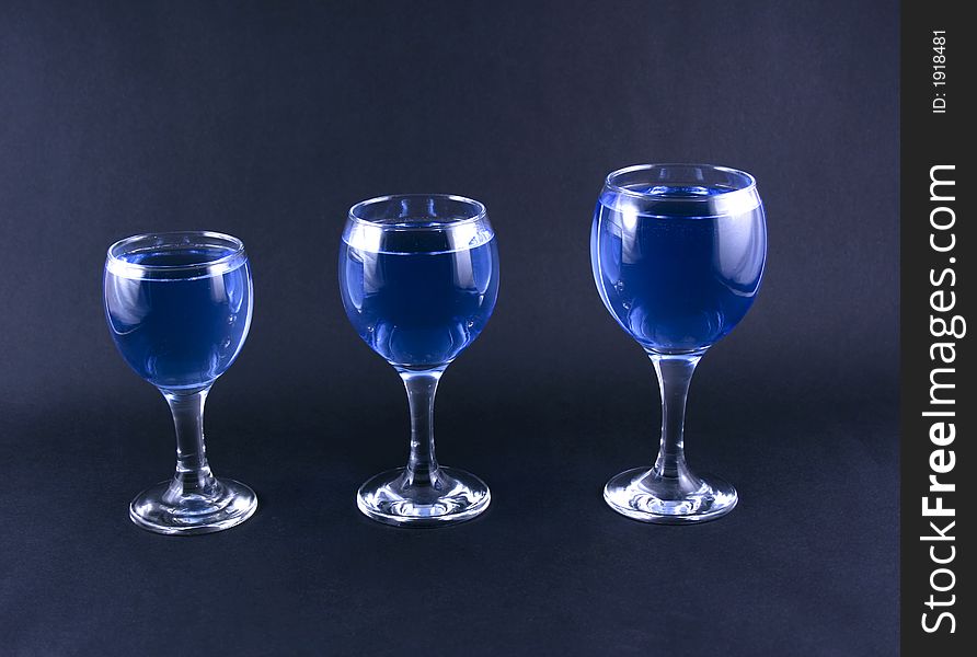 Glasses with a blue drink on a black background