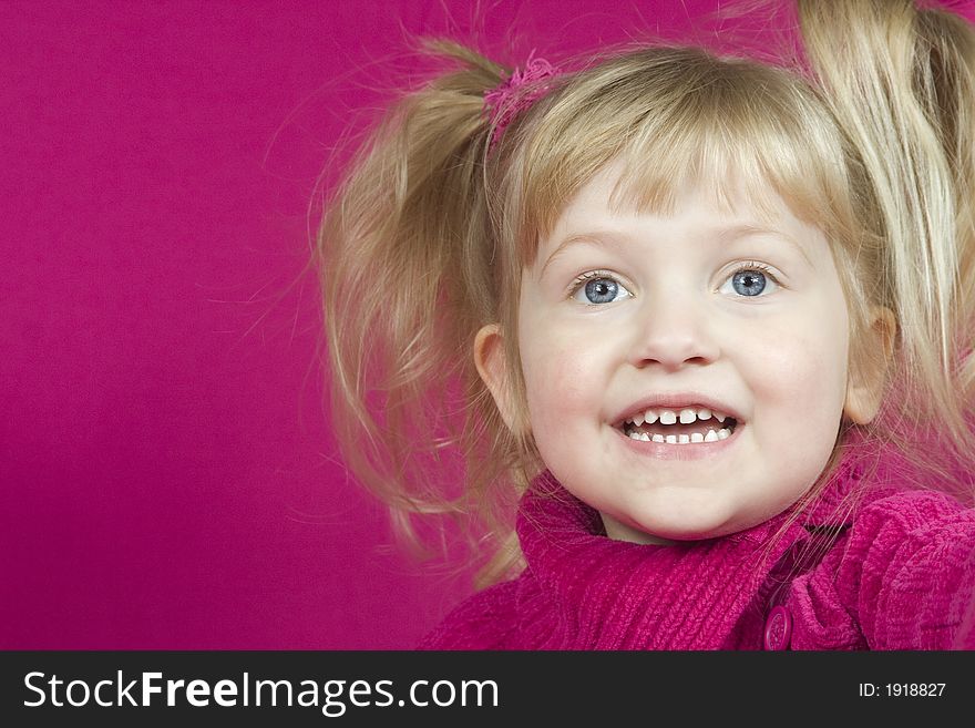 A cute little girl smiling with pink background. A cute little girl smiling with pink background
