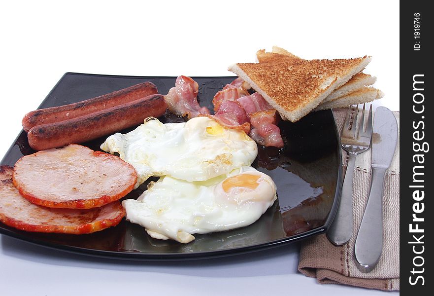 Platter of scrambled eggs with bacon sausages and toast bread