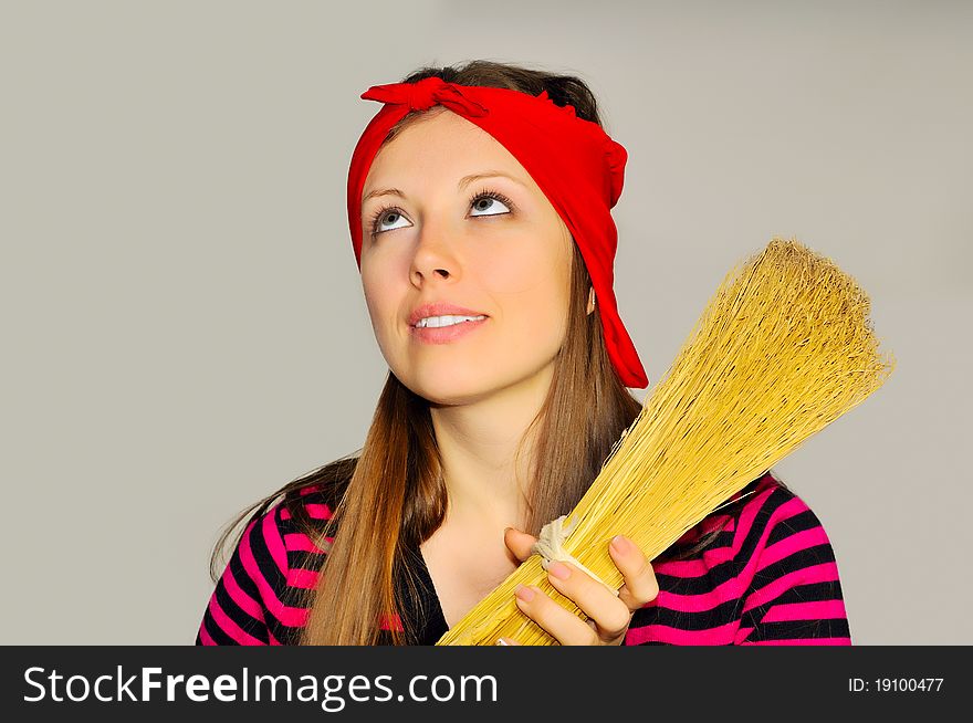 A girl holding a broom and looks up at the ceiling in the apartment. A girl holding a broom and looks up at the ceiling in the apartment