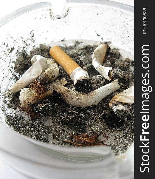 A dirty ashtray full of cigarette ends. A dirty ashtray full of cigarette ends.