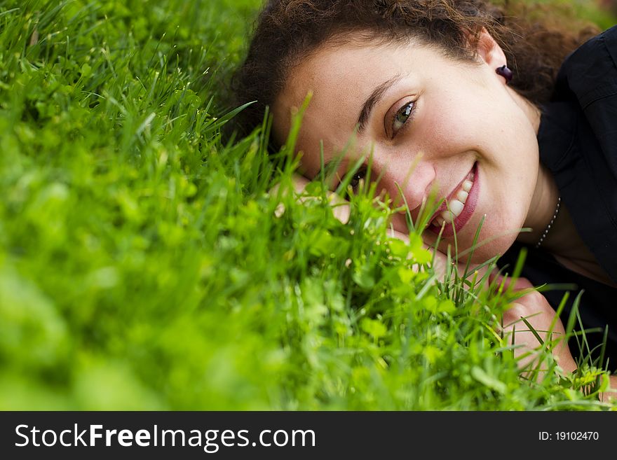 Young happy girl smiling at camera over the grass. Young happy girl smiling at camera over the grass