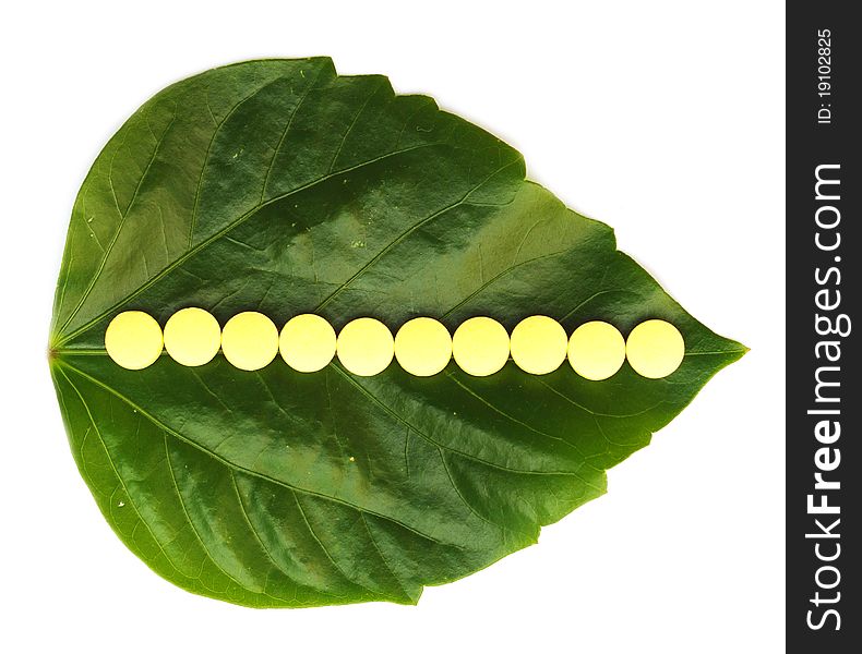 Yellow pill over a green leaf