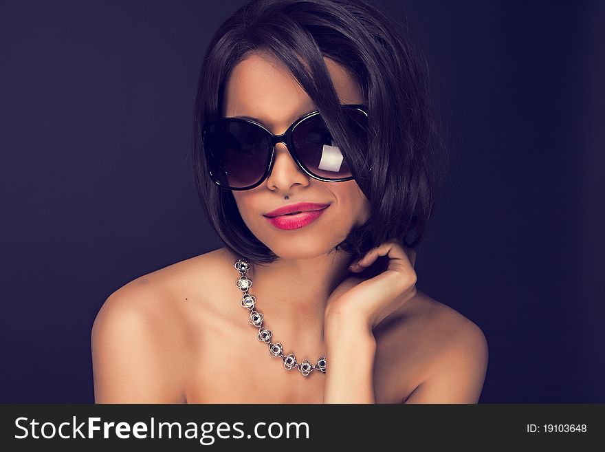 brunette elegant woman wearing sunglasses and neckles. brunette elegant woman wearing sunglasses and neckles