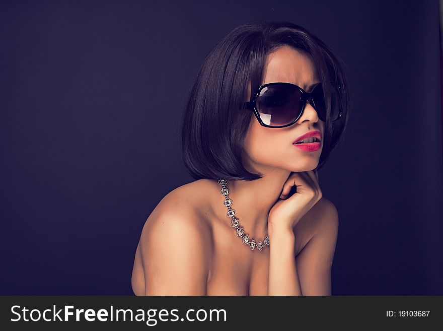 Sexy brunette elegant woman wearing sunglasses and neckles