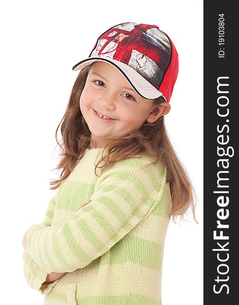 Young girl with red cap and green jumper smiling and looking