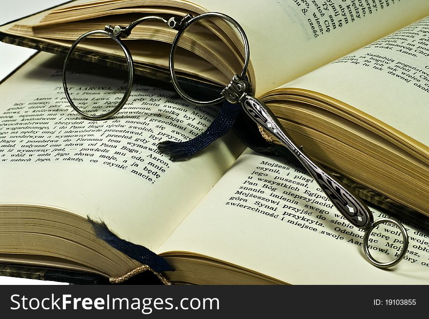 Stack of old books and lorgnette