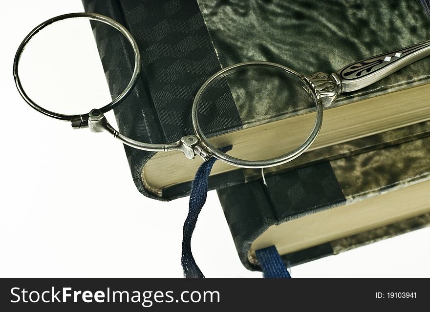 Stack of old books and lorgnette