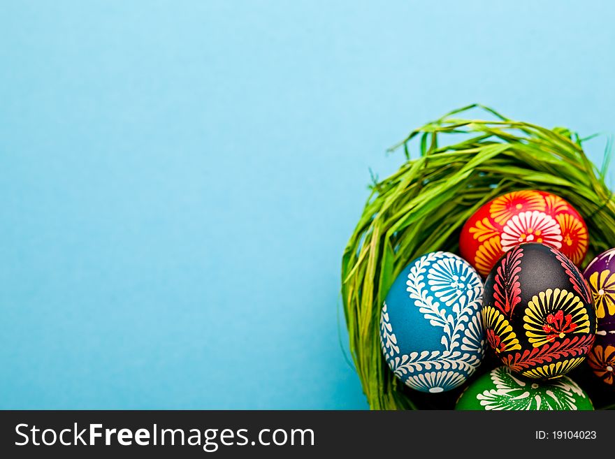 Painted easter eggs in basket on blue background. Painted easter eggs in basket on blue background