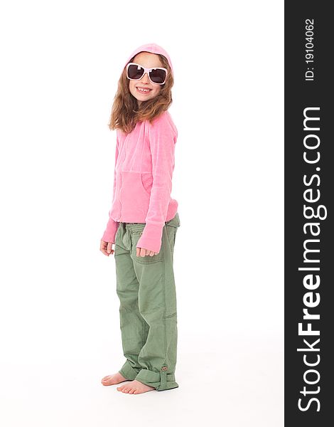 Young girl standing in pink top and green trouser pants and hood looking and smiling. Young girl standing in pink top and green trouser pants and hood looking and smiling