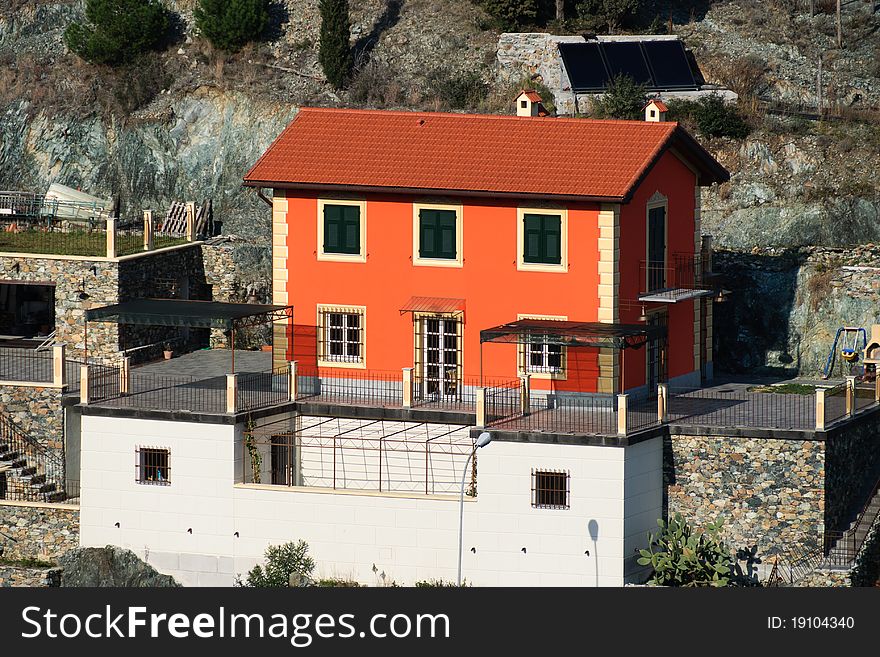 Orange house under construction with stone walls