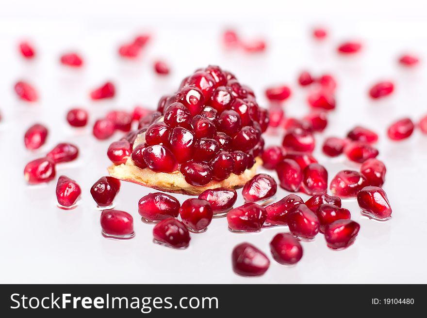 Part of pomegranate with seeds on the white