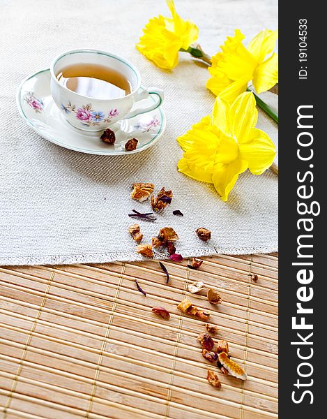 A cup of tea and dry fruit with daffodils. A cup of tea and dry fruit with daffodils