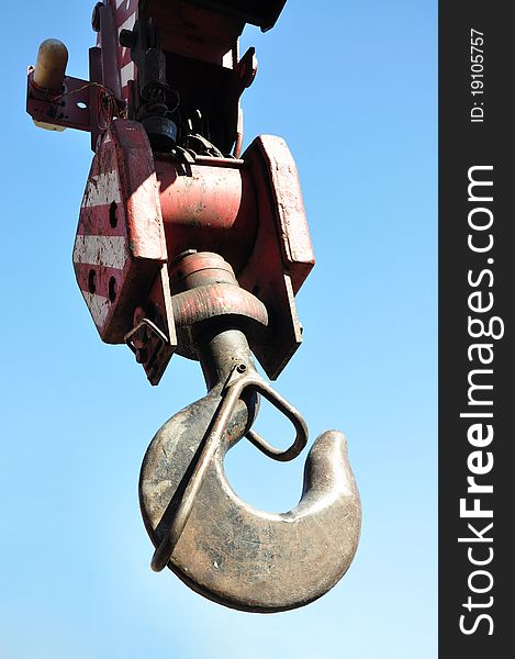 Metal hook of the crane. Against the sky.