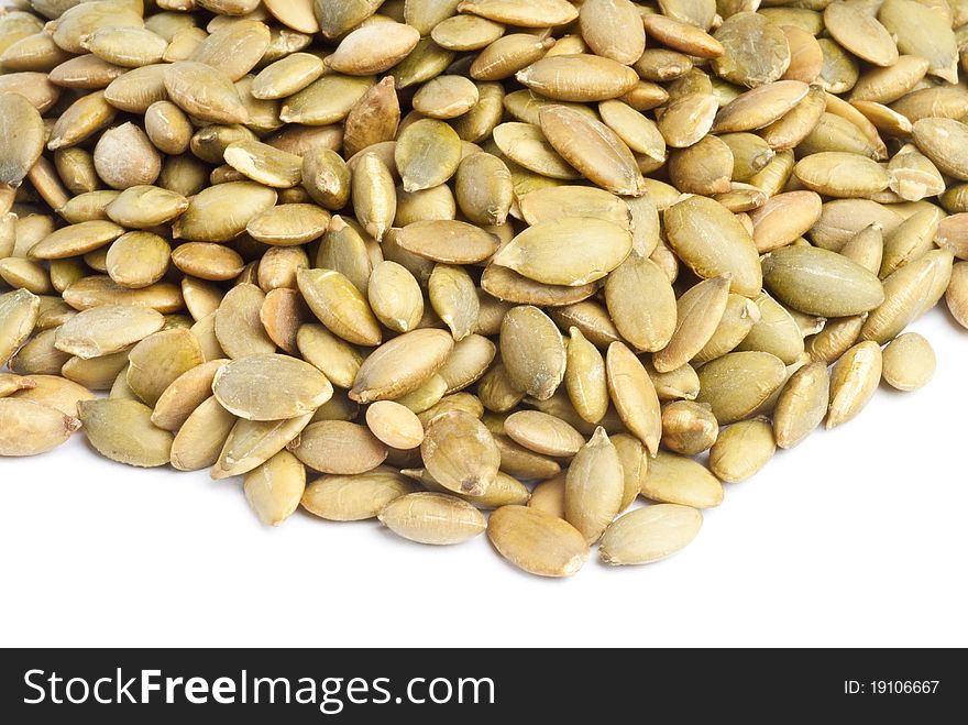 Pile of toasted pumpkin seeds isolated on white.