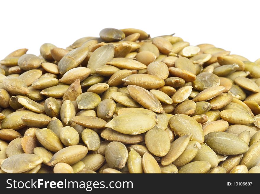 Pile of toasted pumpkin seeds isolated on white.