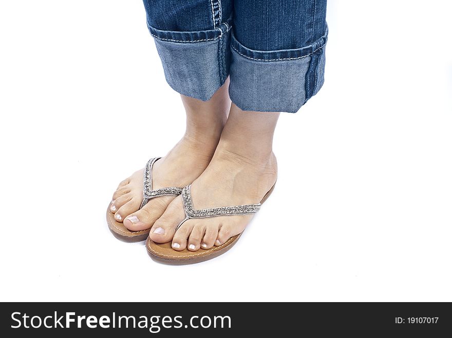 Woman wearing capri blue jeans and a pair of stylish flip flops isolated on white. Woman wearing capri blue jeans and a pair of stylish flip flops isolated on white.