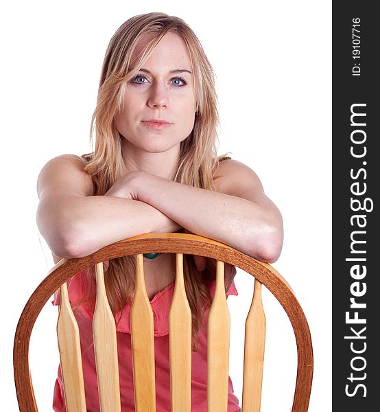 A girl sits backwards on a chair with her arms crossed. A girl sits backwards on a chair with her arms crossed.