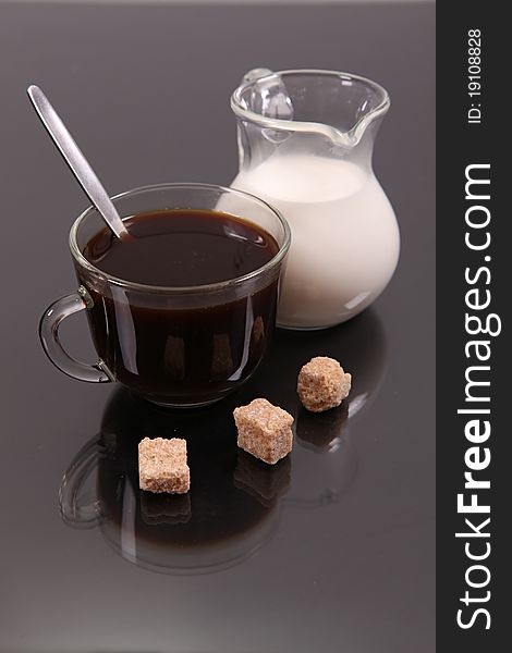 Coffee with milk and wafers against a dark background with reflexion