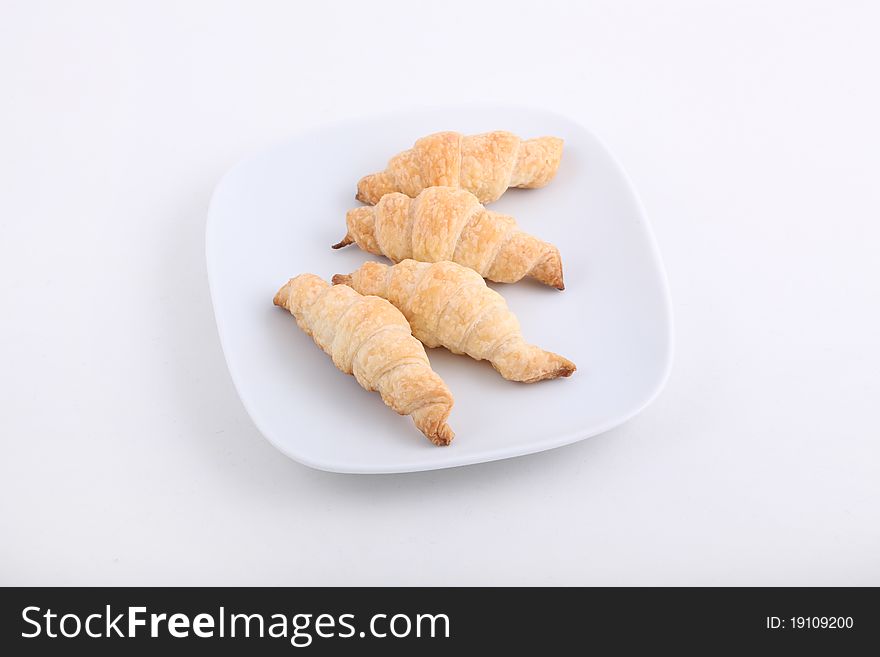 Croissant isolated on white plate