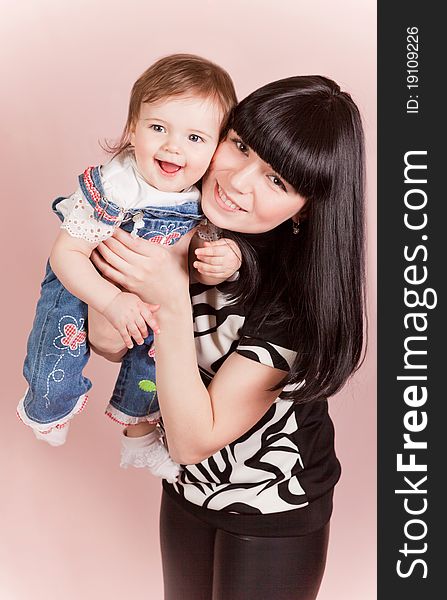 Stock Photo: Happy joyful mother with laughing little daughte in studio