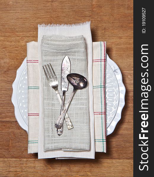 Tarnished cutlery on vintage clothes as a table setting. Tarnished cutlery on vintage clothes as a table setting