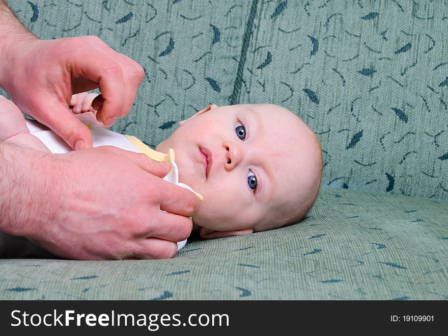 Cute baby boy is getting dressed by father. Cute baby boy is getting dressed by father