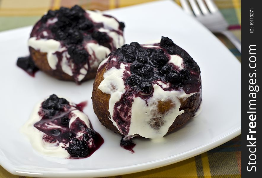 Cream cake with blueberry jam on white plate