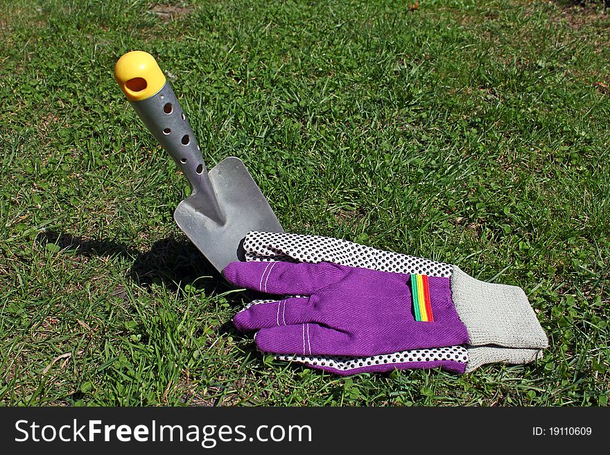 A shovel and gloves on the lawn