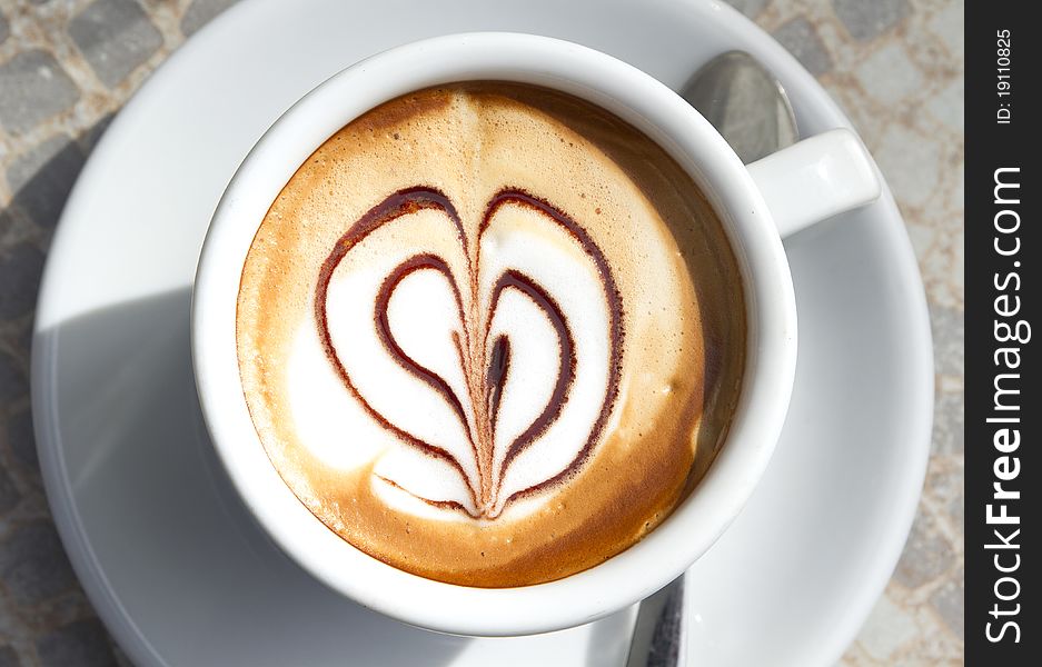 A cup of coffee macchiato with heart-shaped decoration. A cup of coffee macchiato with heart-shaped decoration