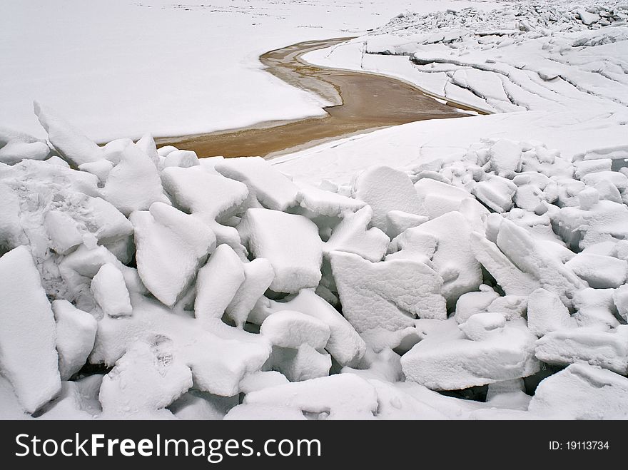 Ice at the sea coast winter cold white crack snow grey white dark sky