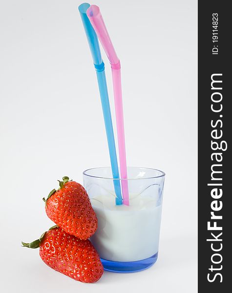 Glass of milk with straw and two strawberries. Glass of milk with straw and two strawberries